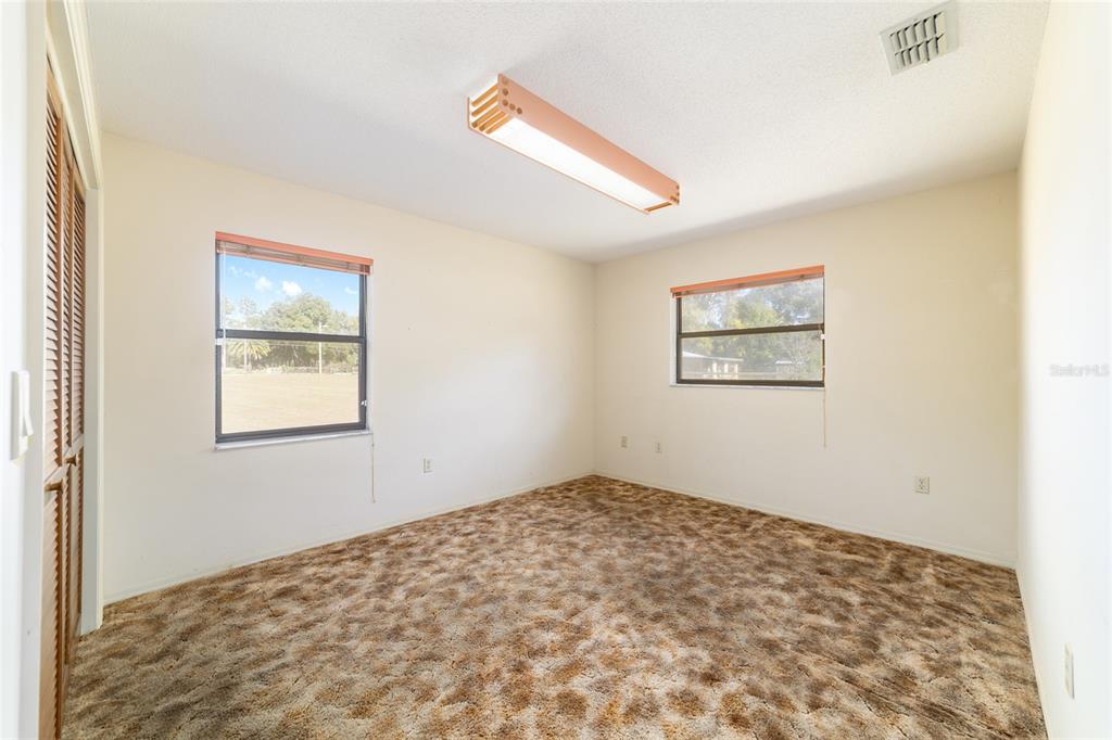 10700 Southeast Sunset Harbor Road Summerfield, FL 34491 - Photo 29 of 41 a view of a big room with wooden floor and windows