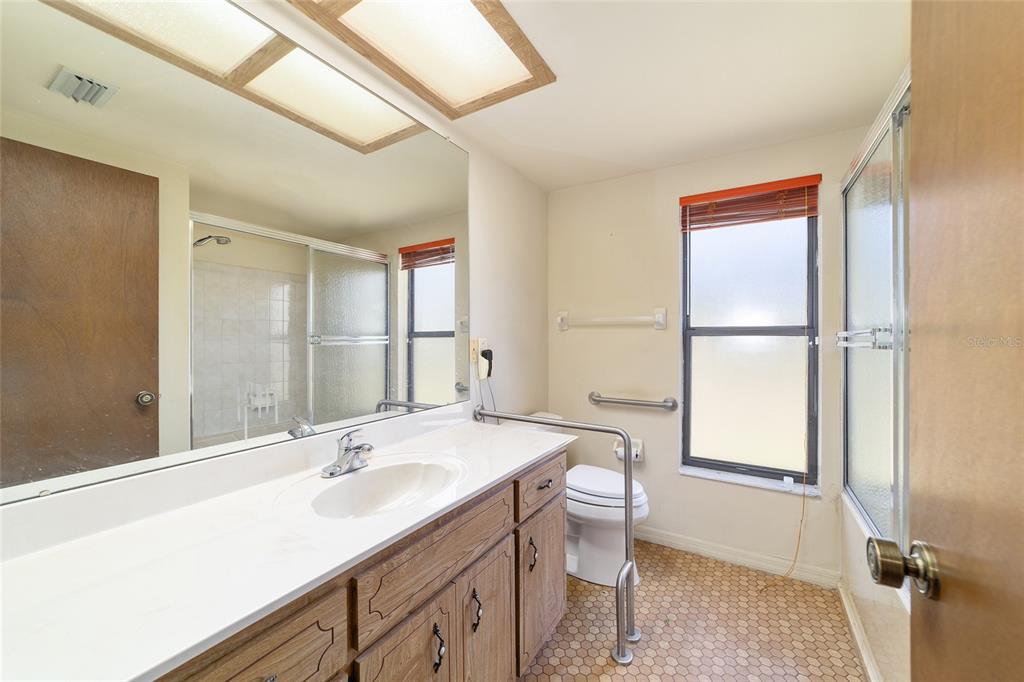 10700 Southeast Sunset Harbor Road Summerfield, FL 34491 - Photo 31 of 41 a bathroom with a sink double vanity mirror and a toilet