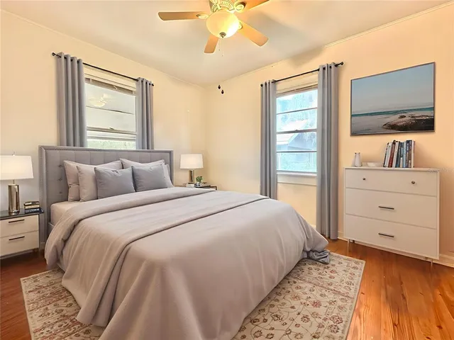 a bedroom with a large bed and a flat tv screen on dresser