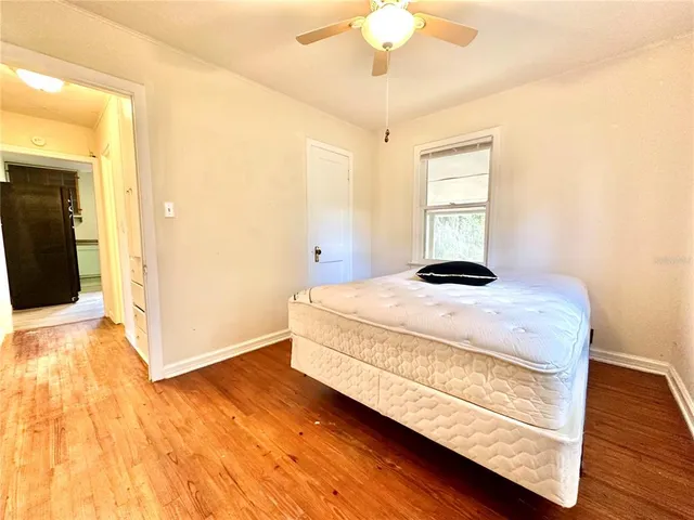 a bedroom with a bed and wooden floor
