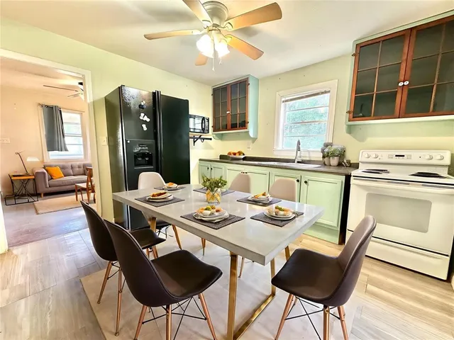 a dining room with stainless steel appliances a table and chairs