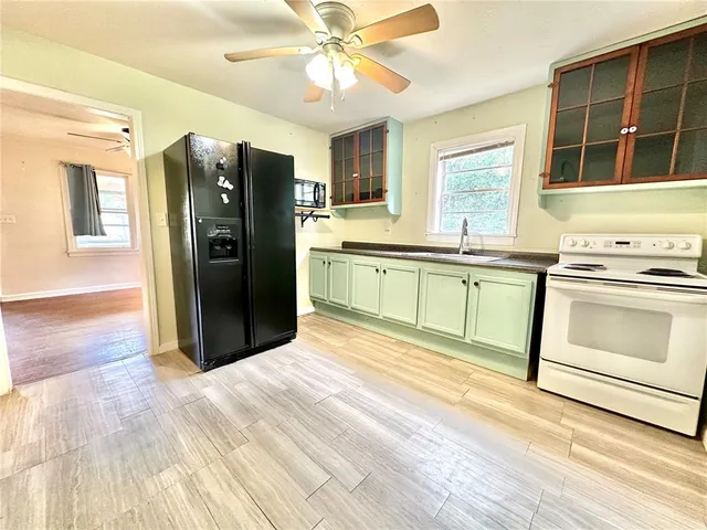 a kitchen with granite countertop a refrigerator stove top oven and sink