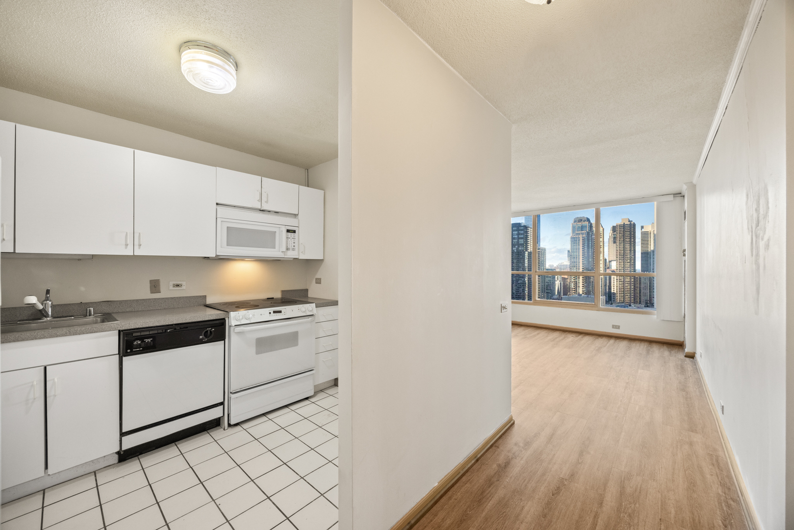 405 North Wabash Avenue, Unit 2801 Chicago, IL 60611 - Photo 17 of 29 a kitchen with granite countertop white cabinets and white appliances