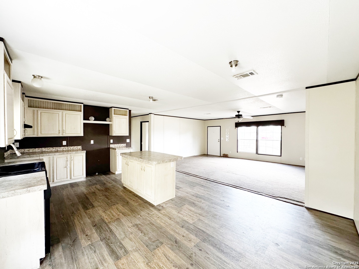808 Pecan Street Jourdanton, TX 78026 - Photo 2 of 17 a large white kitchen with sink a microwave and cabinets