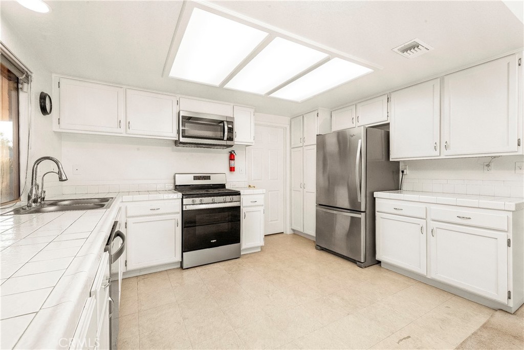 9642 East Ave R 14 Littlerock, CA 93543 - Photo 57 of 66 a kitchen with stainless steel appliances granite countertop a refrigerator sink and stove