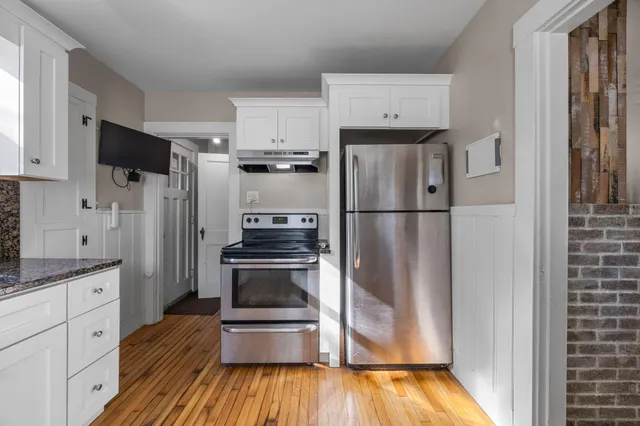 a kitchen with stainless steel appliances a refrigerator stove and wooden cabinets