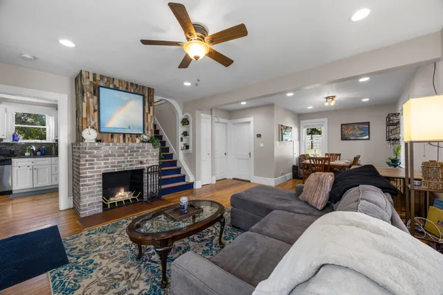a living room with furniture a fireplace and a flat screen tv