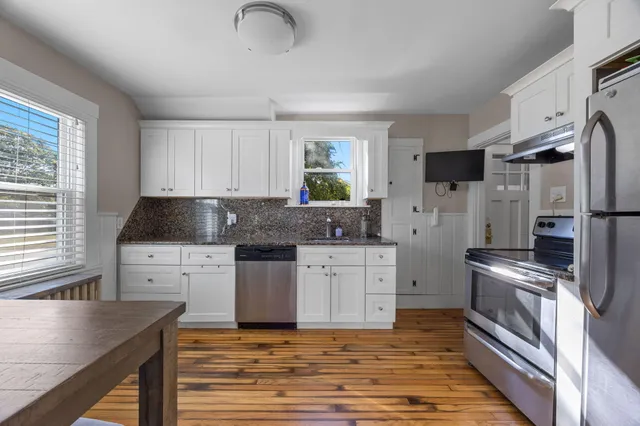 a kitchen with stainless steel appliances granite countertop a stove a sink and a refrigerator