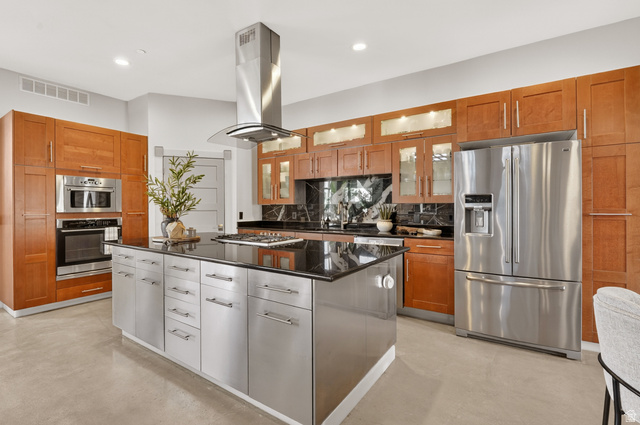 14902 Saddle Leaf Court Draper, UT 84020 - Photo 17 of 52 Dual tone kitchen with stainless steel appliances, glass insert cabinets, dark stone counters, a center island, and concrete flooring