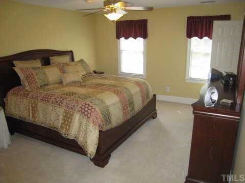 2016 Lovdal Drive Raleigh, NC 27613 - Photo 6 of 10 a large bed sitting in a bedroom next to a window