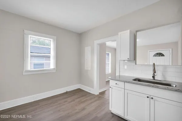 a kitchen with a sink cabinets and wooden floor