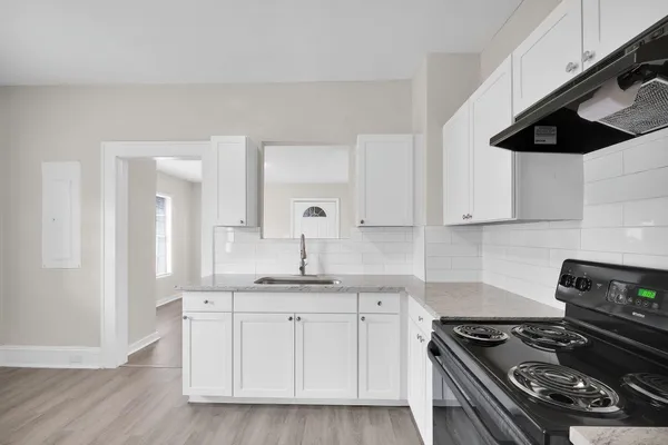 a kitchen with granite countertop a stove and a sink