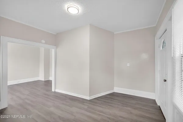a view of an empty room with wooden floor
