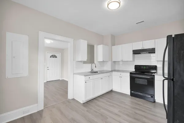 a kitchen with stainless steel appliances granite countertop a stove a sink and a refrigerator