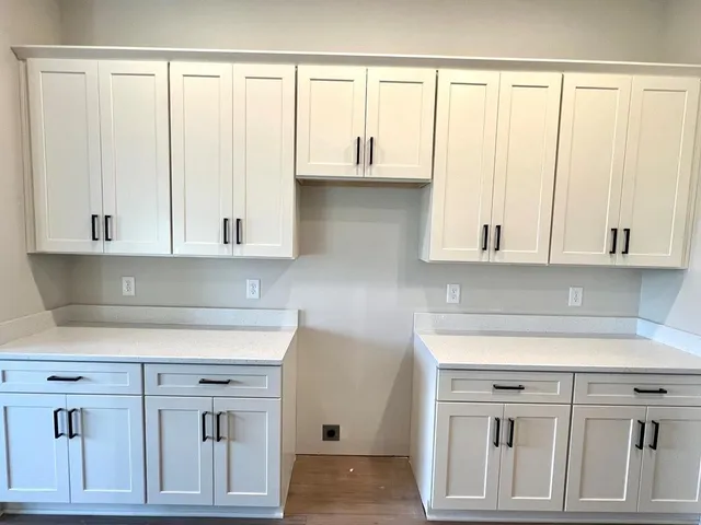 a kitchen with stainless steel appliances granite countertop a sink stove and white cabinets with wooden floor