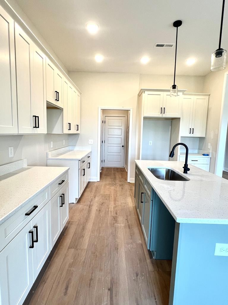 416 Old Major Road Hopkinsville, KY 42240 - Photo 9 of 29 a kitchen with stainless steel appliances granite countertop a sink stove and white cabinets with wooden floor