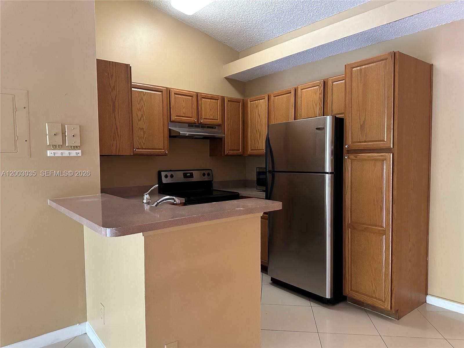 731 Lyons Road, Unit 16203 Coconut Creek, FL 33063 - Photo 5 of 14 a kitchen with metallic refrigerator freezer and a dishwasher