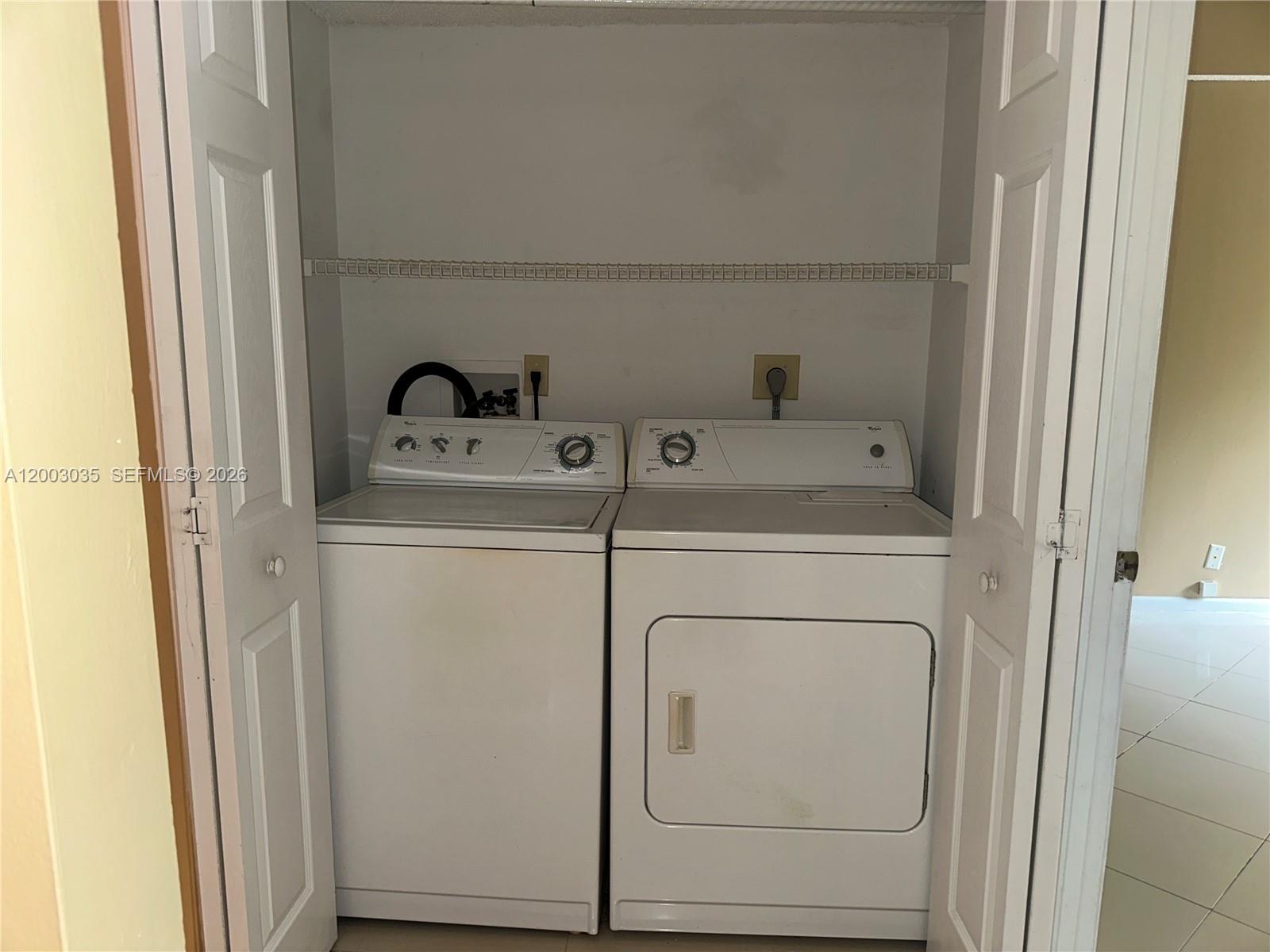 731 Lyons Road, Unit 16203 Coconut Creek, FL 33063 - Photo 9 of 14 a utility room with dryer and washer