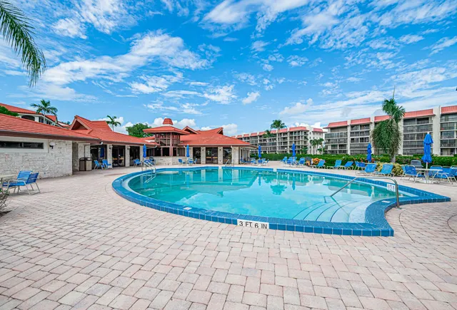 a view of a swimming pool is middle in the backyard