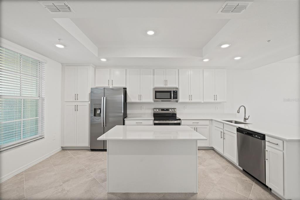 19007 Scallop Loop, Unit 108 Lakewood Ranch, FL 34211 - Photo 13 of 59 a kitchen with stainless steel appliances a refrigerator sink and microwave