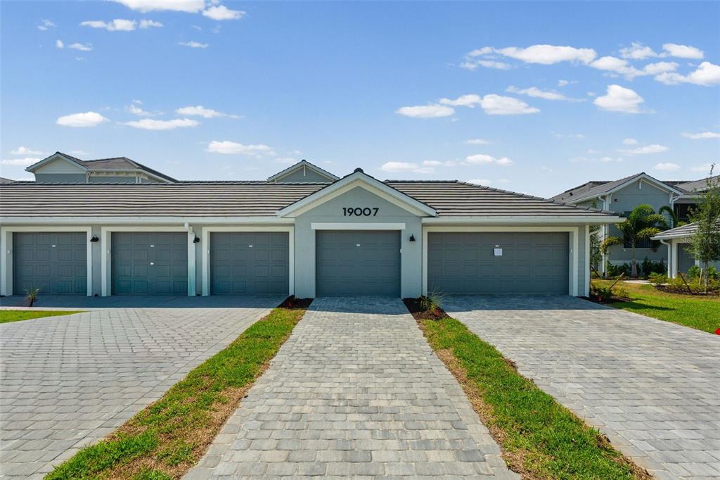19007 Scallop Loop, Unit 108 Lakewood Ranch, FL 34211 - Photo 2 of 59 a front view of house with yard and trees in the background