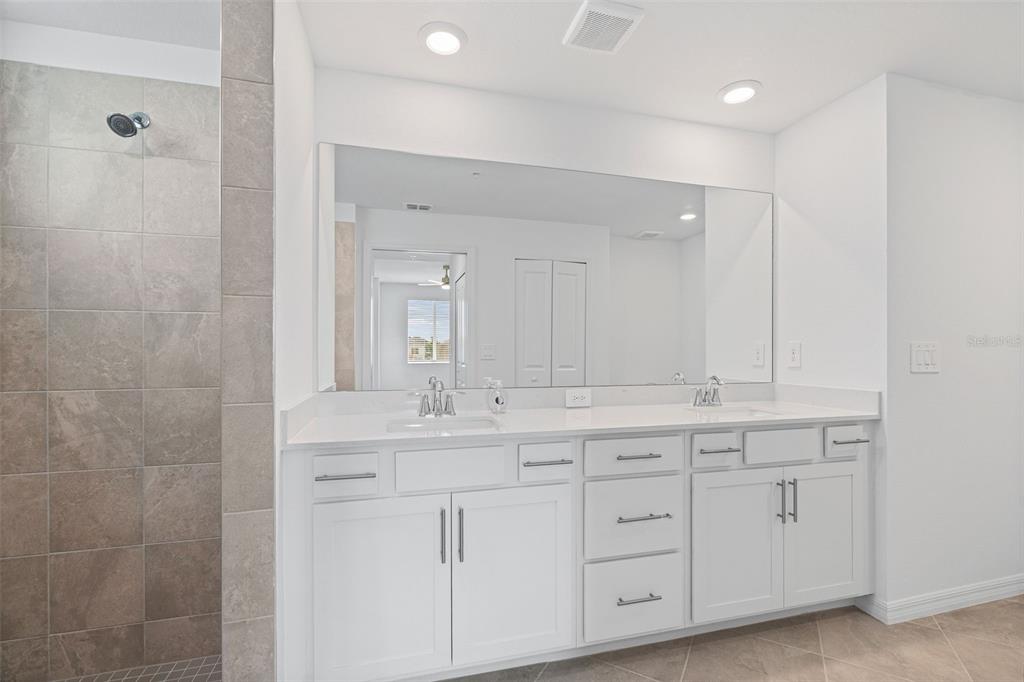 19007 Scallop Loop, Unit 108 Lakewood Ranch, FL 34211 - Photo 21 of 59 a bathroom with a double vanity sink and mirror