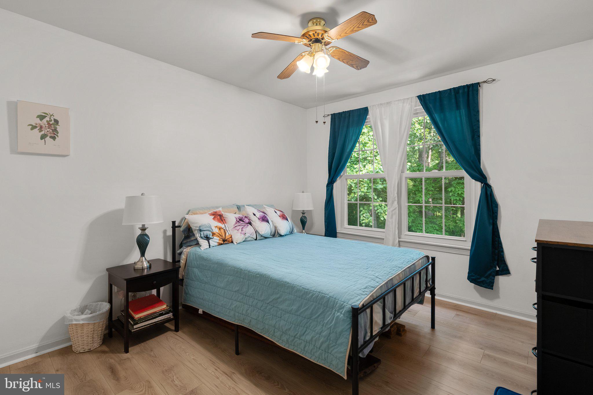20249 Maple Leaf Court Montgomery Village, MD 20886 - Photo 19 of 30 a bedroom with a bed a window and a chandelier