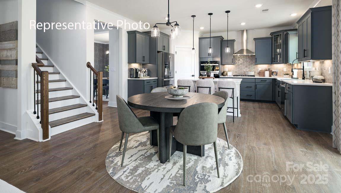 3044 Canvasback Way Indian Trail, NC 28079 - Photo 12 of 43 a view of a dining room and livingroom with furniture wooden floor a rug a fireplace and a chandelier