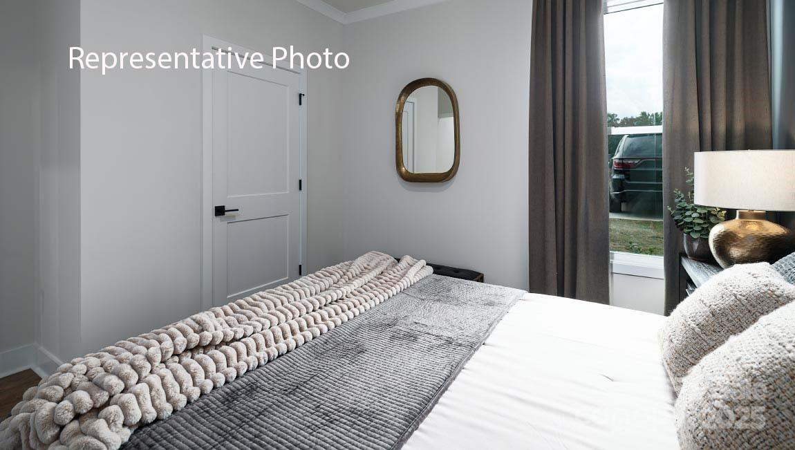 3044 Canvasback Way Indian Trail, NC 28079 - Photo 42 of 43 a bedroom with a bed and a chandelier