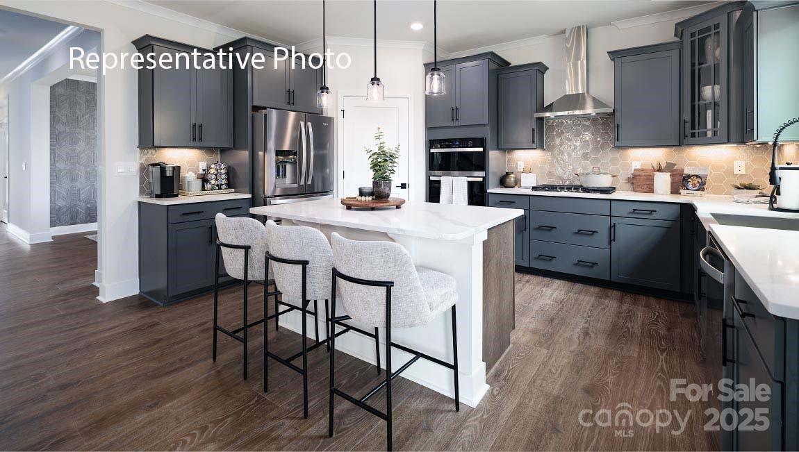 3044 Canvasback Way Indian Trail, NC 28079 - Photo 5 of 43 a kitchen with stainless steel appliances kitchen island granite countertop a table chairs and a refrigerator