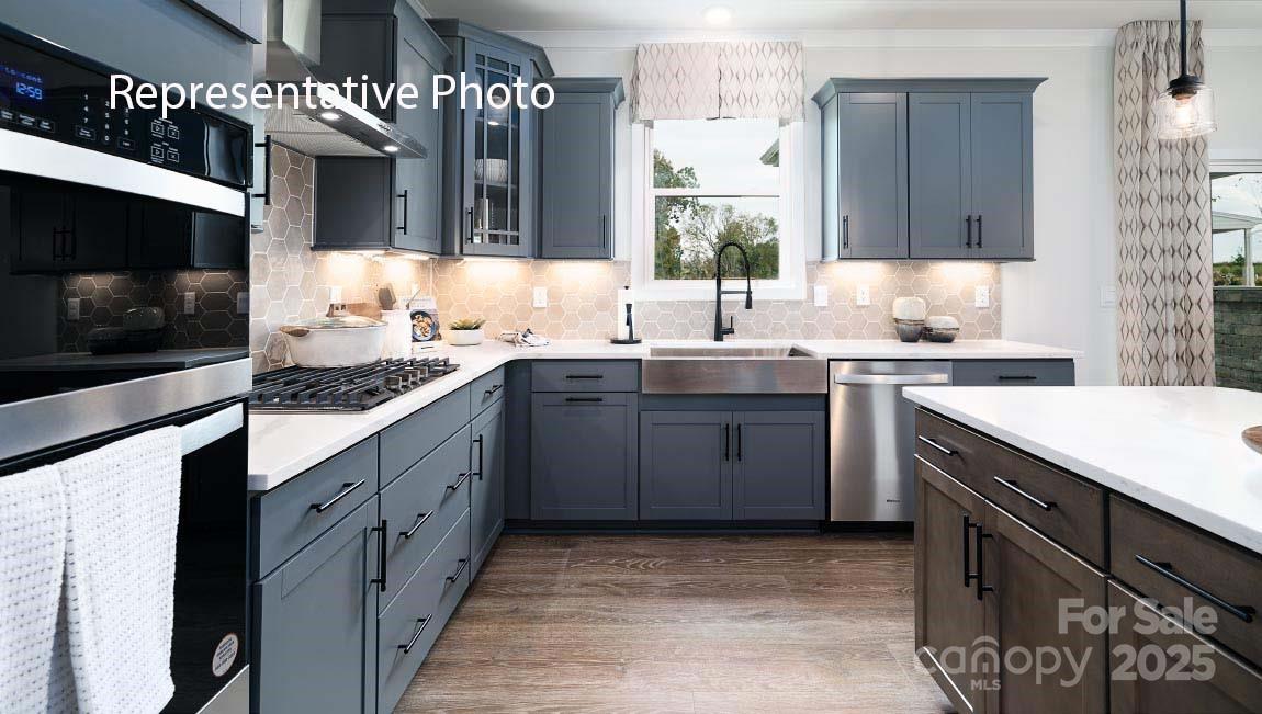 3044 Canvasback Way Indian Trail, NC 28079 - Photo 6 of 43 a kitchen with a sink stove and cabinets