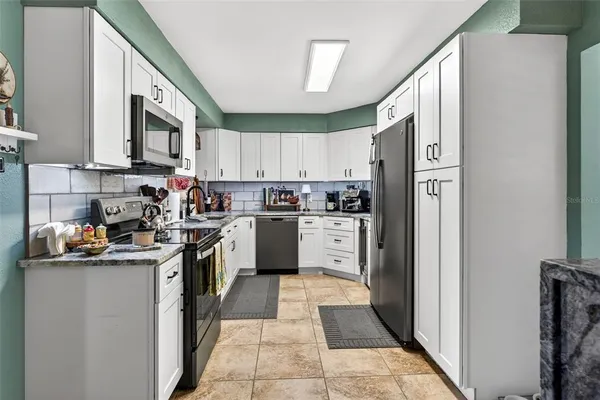 a kitchen with stainless steel appliances granite countertop a refrigerator sink and cabinets