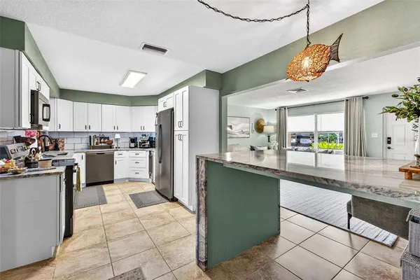 a kitchen with cabinets and chairs