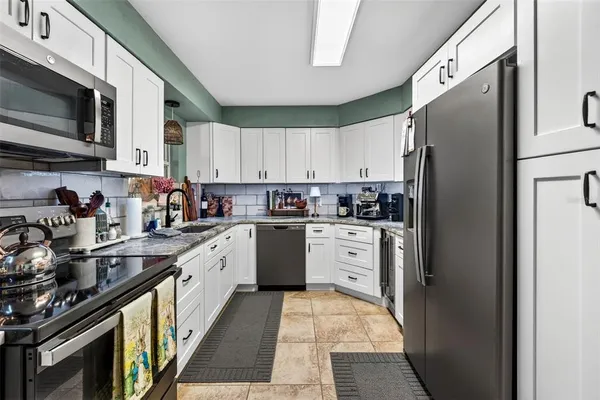 a kitchen with stainless steel appliances a refrigerator sink and cabinets