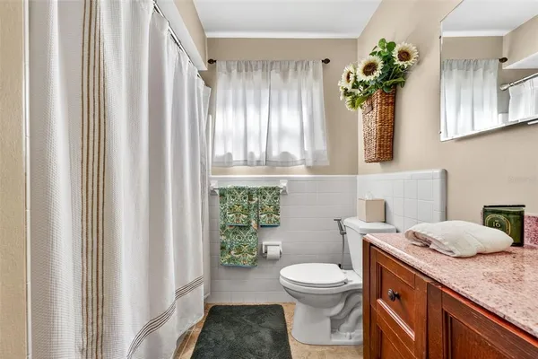 a bedroom with a bed a chandelier and a mirror on the dresser
