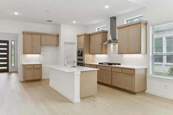 a kitchen with stainless steel appliances granite countertop a stove a sink and a refrigerator