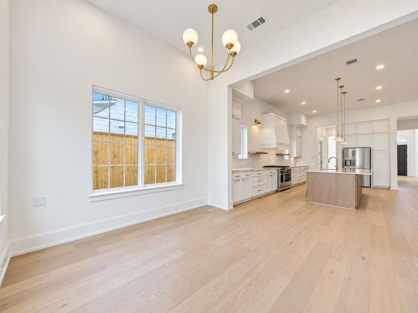 2309 Hollister Road Houston, TX 77080 - Photo 13 of 47 Light-filled breakfast room offers a stylish setting for casual dining, morning coffee, and everyday gatherings. Soaring ceilings, wide-plank flooring, a chic statement chandelier, and generous windows create an airy, sophisticated ambiance, while the open connection to the chef-inspired kitchen keeps conversation and entertaining flowing effortlessly.