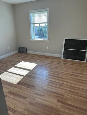 a view of a livingroom with wooden floor and window