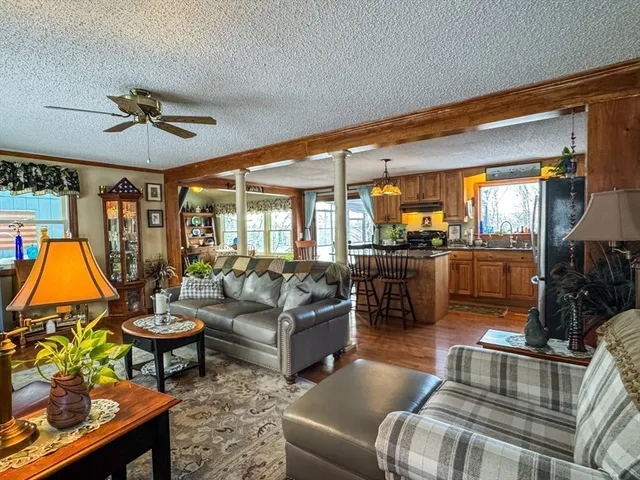 a living room with fireplace furniture and a large window