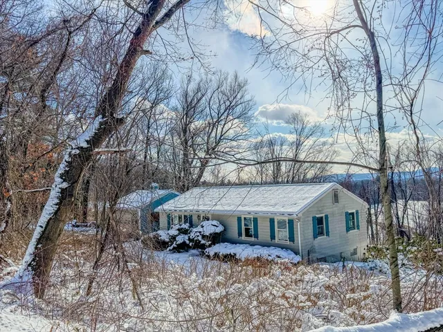 a front view of house with yard covered in snow