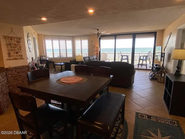 a large dining room with furniture a chandelier and wooden floor
