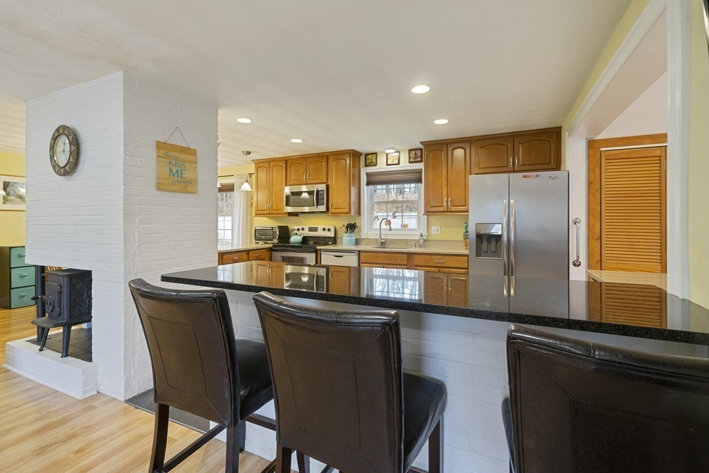26 Edith Road Framingham, MA 01701 - Photo 11 of 42 a kitchen with stainless steel appliances granite countertop a sink a stove a refrigerator a dining table and chairs with wooden floor