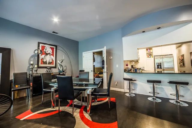 a living room with furniture kitchen view and a large window