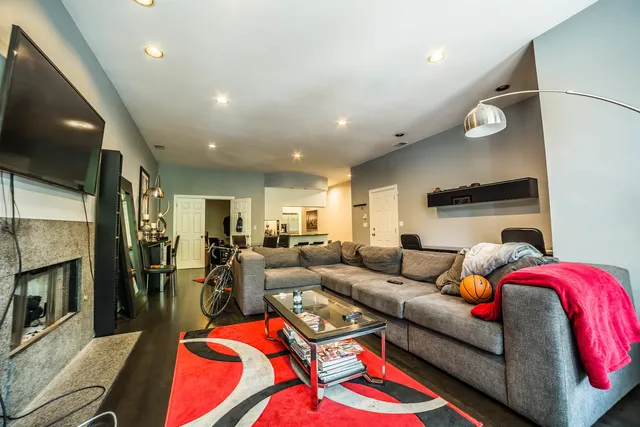 a living room with furniture a flat screen tv and a fireplace