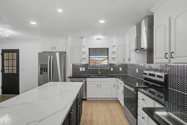 a kitchen with stainless steel appliances a sink stove and refrigerator