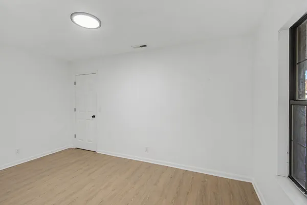 a view of an empty room with wooden floor