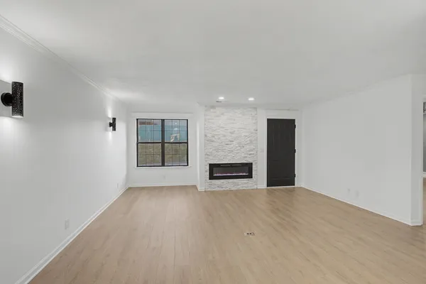 a view of an empty room with a fireplace and a window