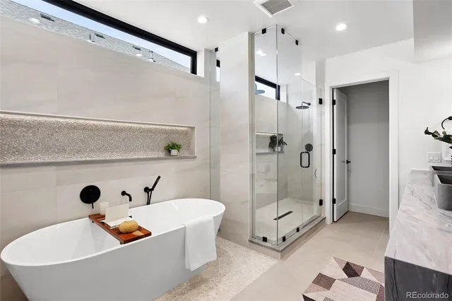 a bathroom with a tub a shower and view