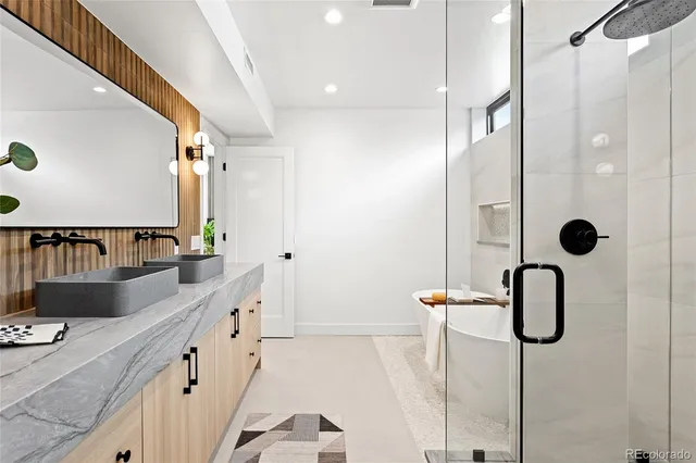 a bathroom with a double vanity sink a mirror and shower