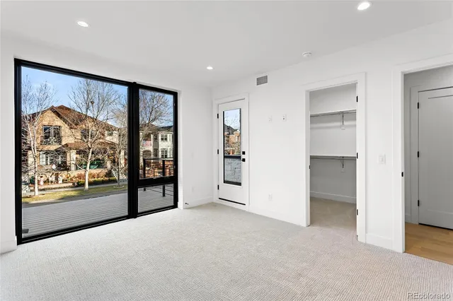 a view of a big room with large windows and cabinet